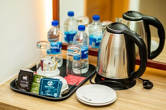 Kettle, cups and bottled water set on the in-room tea tray.