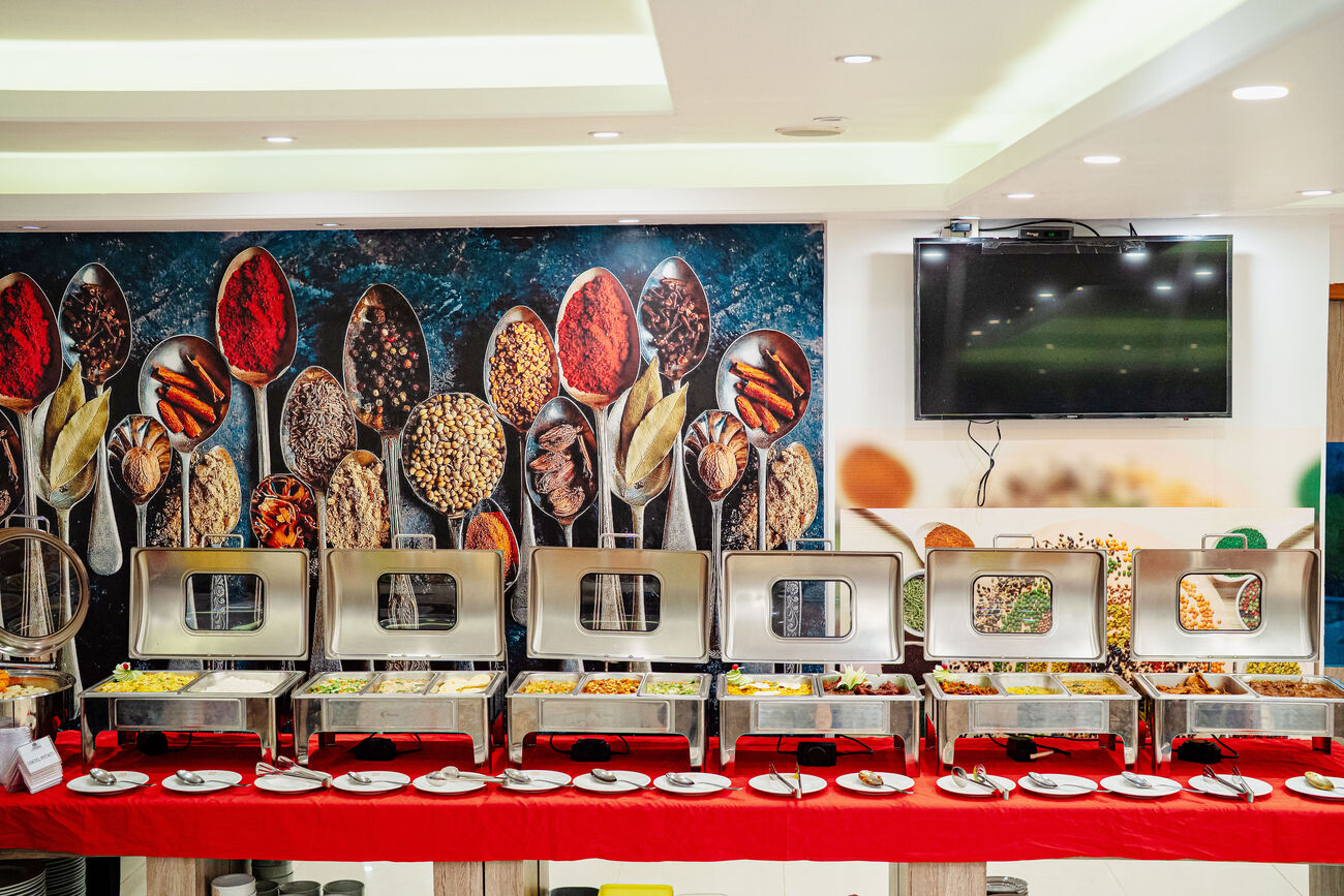 Breakfast buffet counters set out beneath a wall painted with spices.