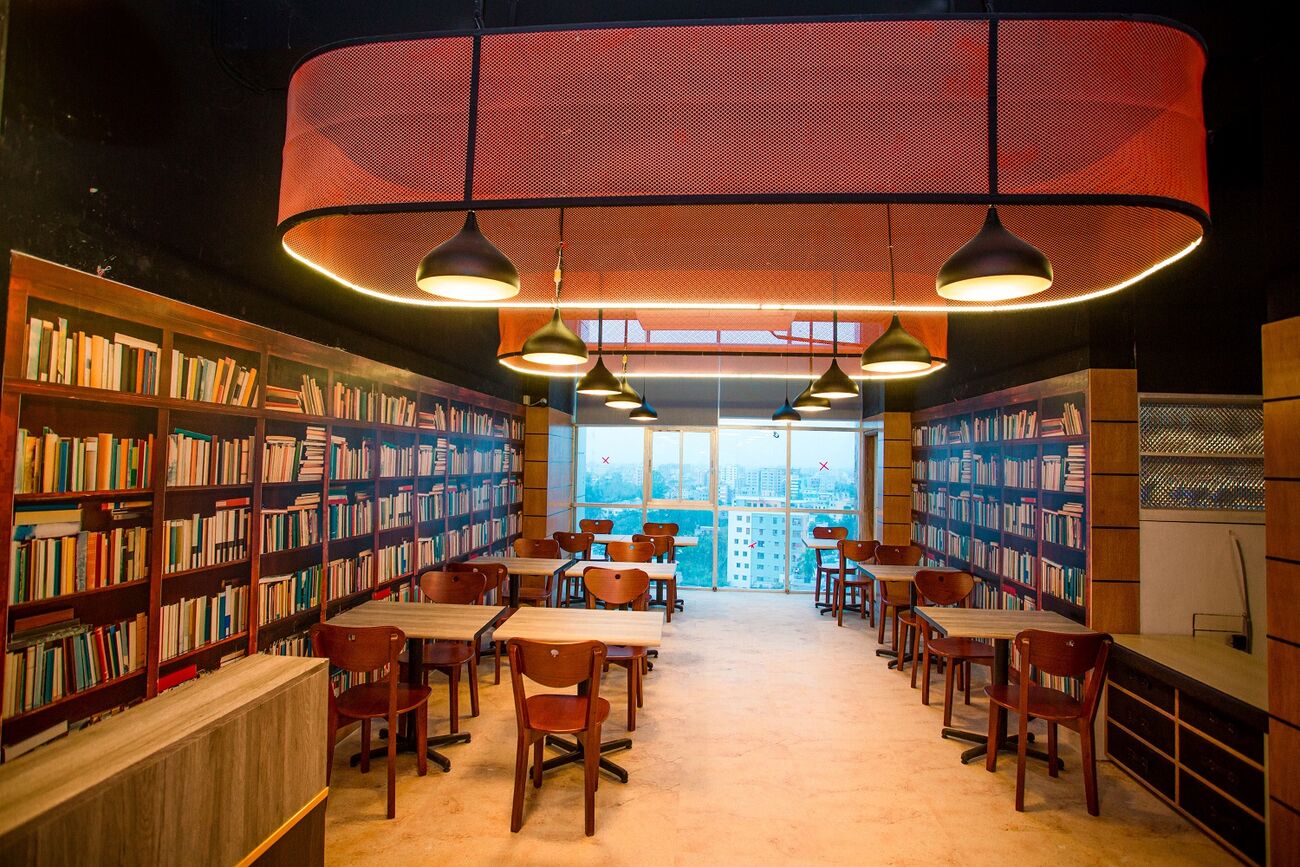 Royal Café, bookshelves floor to ceiling with small tables and hanging lamps.