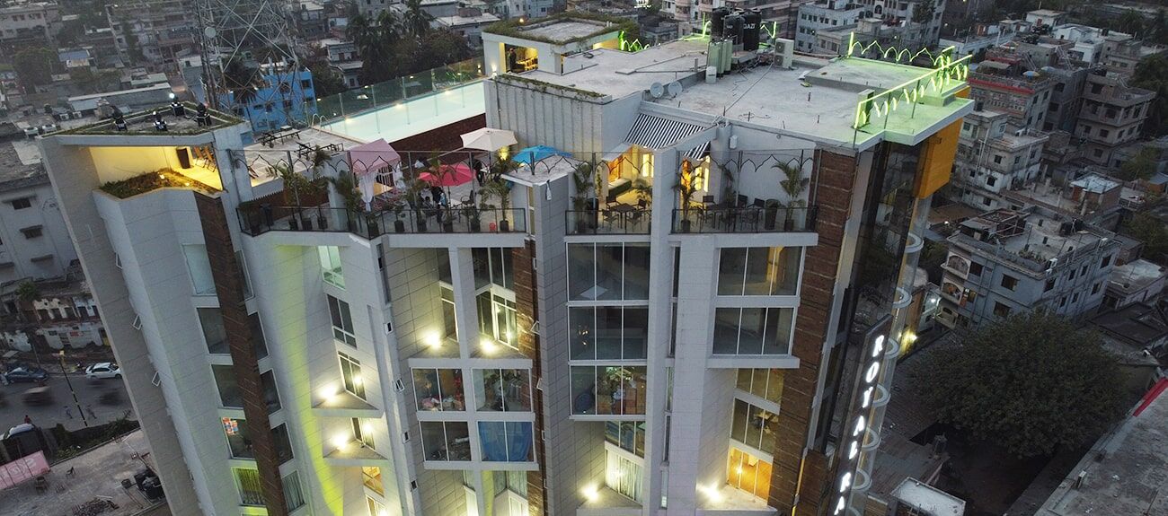 The hotel seen from the air, rising above the rooftops of central Rajshahi.