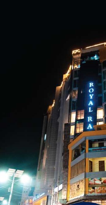 The Royal Raj tower lit at night, its vertical sign reading Royal Raj above Gonokpara road.