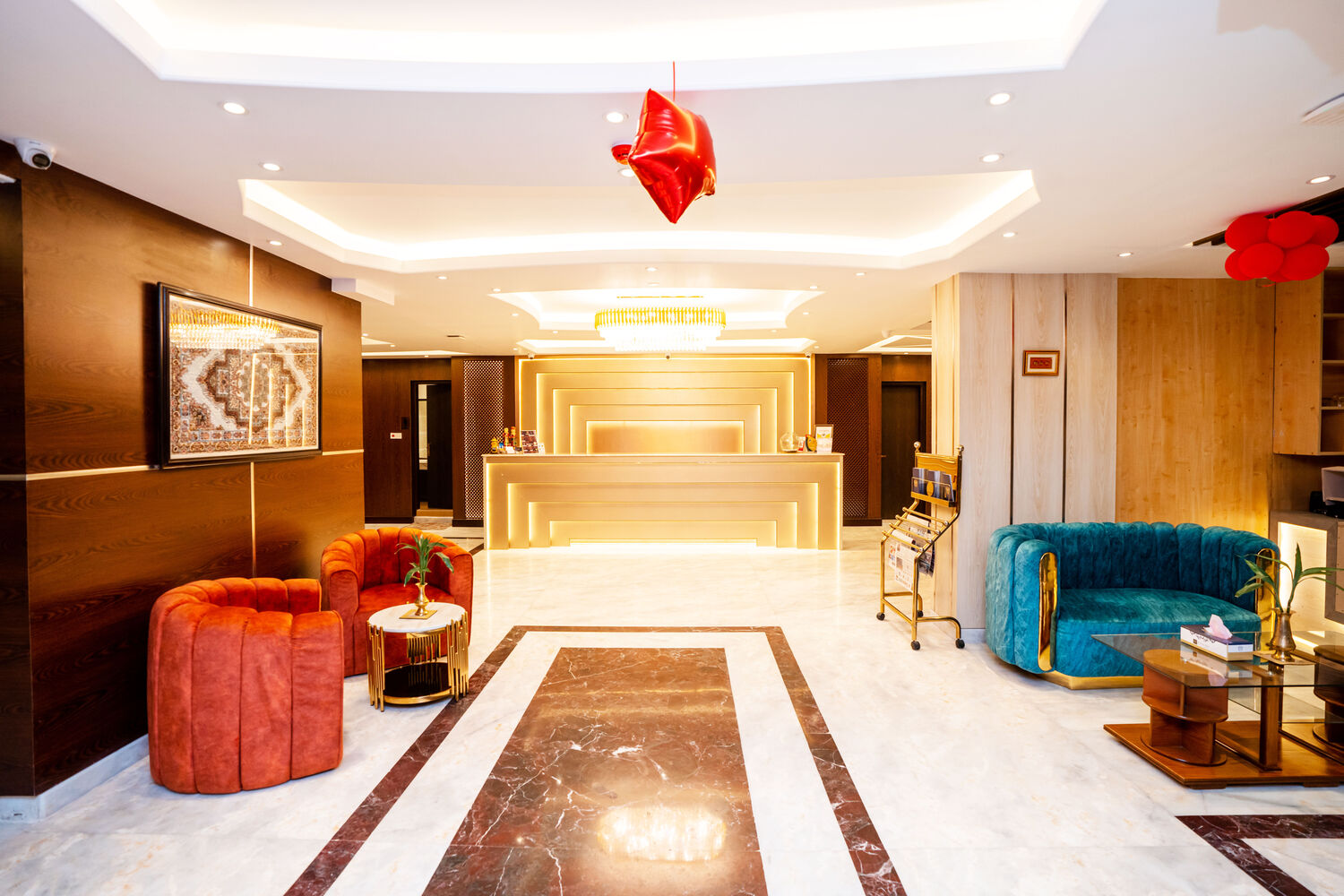 The marble lobby, gold panelling and jewel-coloured seating along a long runner.