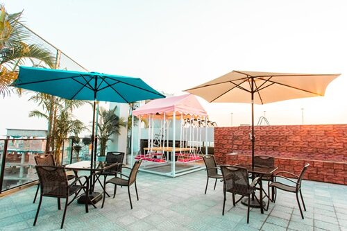 Umbrellas and tables on the roof terrace beside the pool.