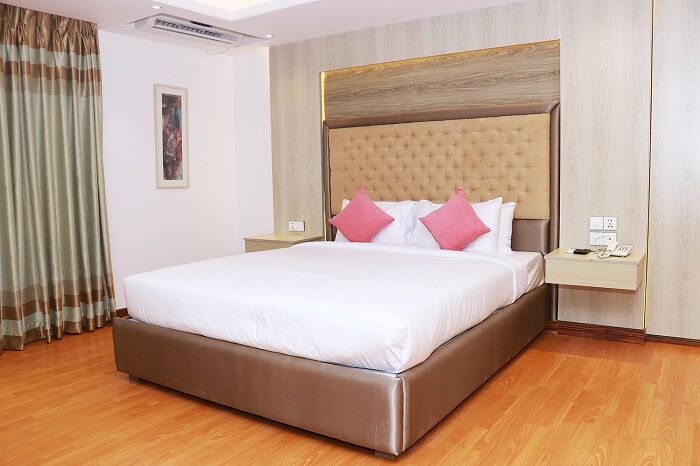 Junior Suite with a tall tufted headboard and a wood floor.