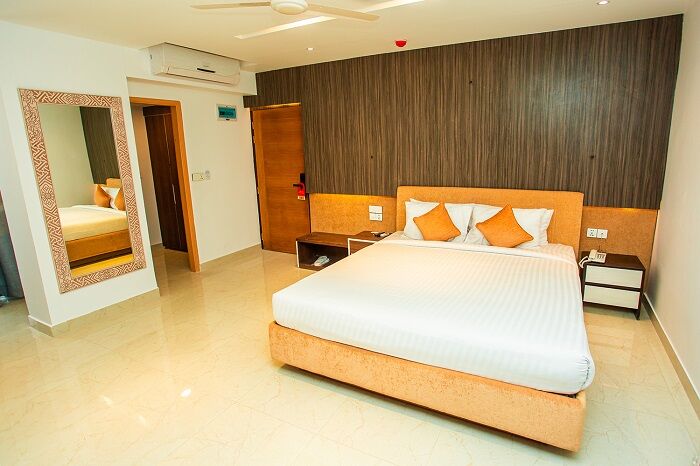 Premium Single room with a dark wood feature wall and a long mirror.